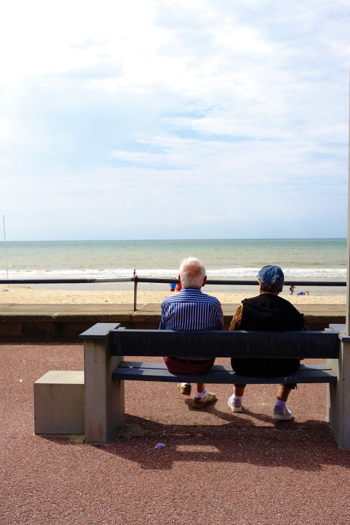 A serene scene of an elderly couple enjoying the view at Le Touquet beach, France.